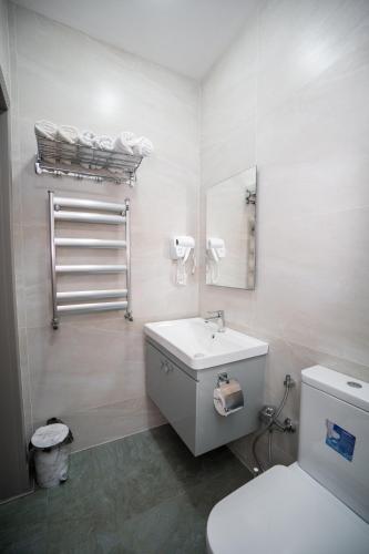 a bathroom with a white sink and a toilet at North Hotel in Qusar