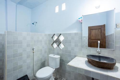 ein Badezimmer mit Waschbecken, Toilette und Spiegel in der Unterkunft Creative Trawangan Stay in Gili Trawangan