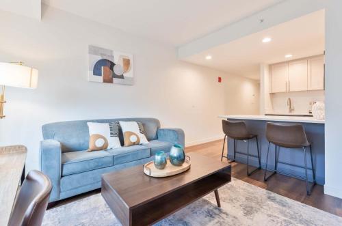 a living room with a blue couch and a table at Luxury Apt Near Kendall Square in Cambridge