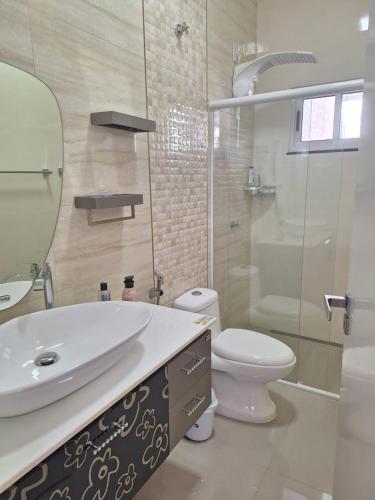 a bathroom with a sink and a toilet and a shower at Casa Bourbon in Foz do Iguaçu