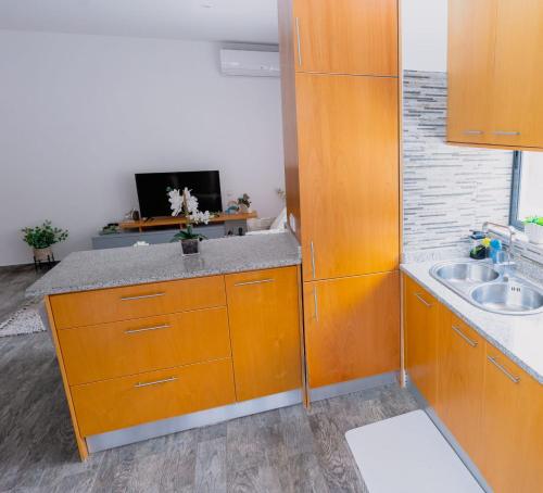 a kitchen with orange cabinets and a sink at Apartamentos Modernos Santo Antão in Ribeira Grande