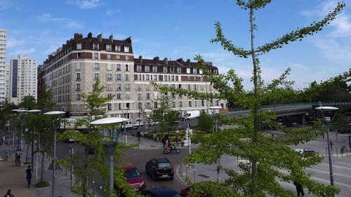 eine Stadt mit einem Gebäude und einer Straße mit Autos in der Unterkunft Appartement moderne avec Wi-Fi et Balcon in Choisy-le-Roi