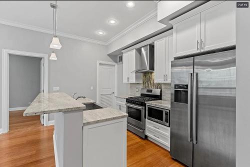 a kitchen with stainless steel appliances and white cabinets at Private Balcony 1 Garage Parking Sleeps 6 in Chicago