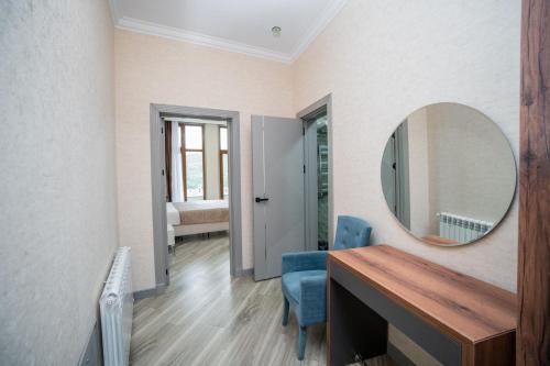 a room with a mirror and a table and chairs at North Hotel in Qusar