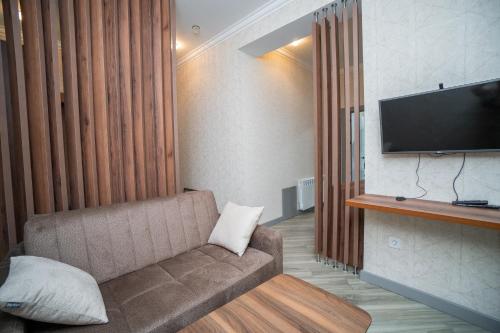a living room with a couch and a flat screen tv at North Hotel in Qusar
