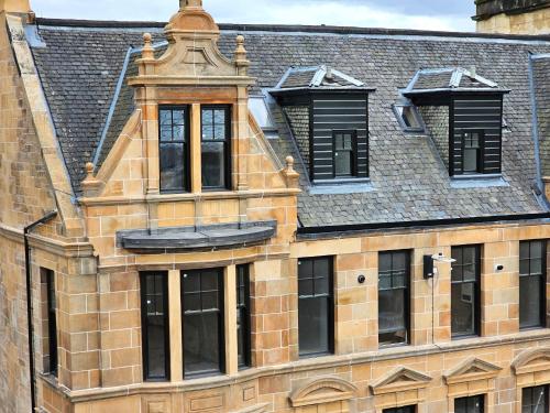 an old brick building with windows and a roof at 6 Smithhills - Sleeps 3 Central Excellent Transport Links Glasgow & Airport in Paisley