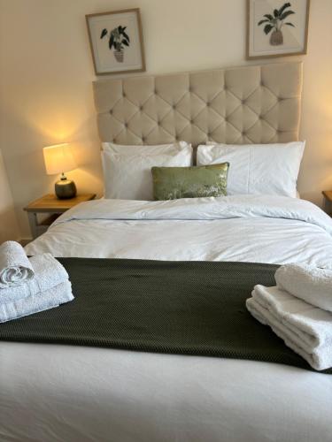 a bedroom with a white bed with towels on it at 6 Smithhills - Sleeps 3 Central Excellent Transport Links Glasgow & Airport in Paisley