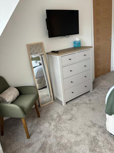 a bedroom with a dresser and a tv and a mirror at 6 Smithhills - Sleeps 3 Central Excellent Transport Links Glasgow & Airport in Paisley