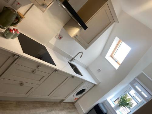 an overhead view of a kitchen with white cabinets and a window at 6 Smithhills - Sleeps 3 Central Excellent Transport Links Glasgow & Airport in Paisley