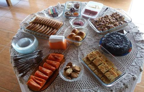 uma mesa coberta com bandejas de diferentes tipos de alimentos em Fazenda Fernandes, pousada, gastronomia e lazer. em Treviso