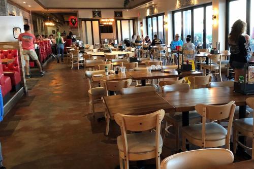 a restaurant with wooden tables and chairs and people at Cozy Studio Suite Near Beach W Kitchenette #11 in Daytona Beach Shores
