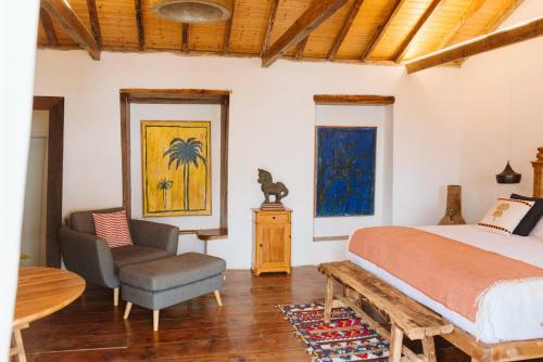 a bedroom with a bed and a chair and a table at Dreamsea Boutique Experience in Moya