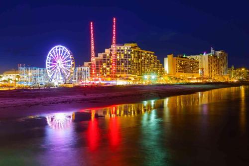 a city skyline with a ferris wheel at night at Cozy Studio Suite Near Beach W Kitchenette #11 in Daytona Beach Shores