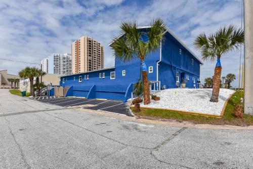 a blue building with palm trees in a parking lot at Cozy Studio Suite Near Beach W Kitchenette #11 in Daytona Beach Shores