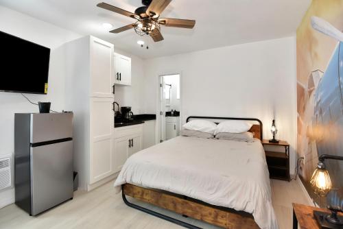 a white bedroom with a bed and a ceiling fan at Cozy Studio Suite Near Beach W Kitchenette #3 in Daytona Beach Shores