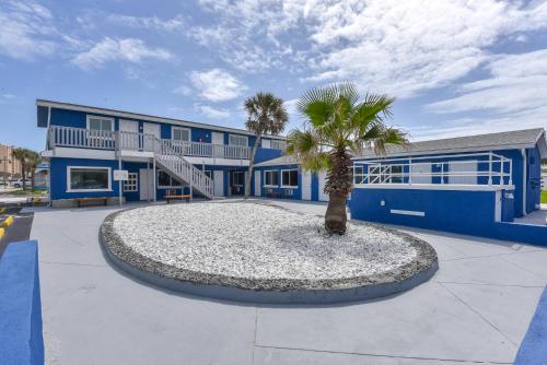 a palm tree in front of a blue building at Cozy Studio Suite Near Beach W Kitchenette #3 in Daytona Beach Shores