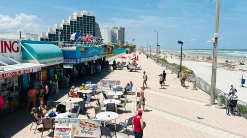 a group of people walking on a sidewalk near the beach at Cozy Studio Suite Near Beach W Kitchenette #3 in Daytona Beach Shores