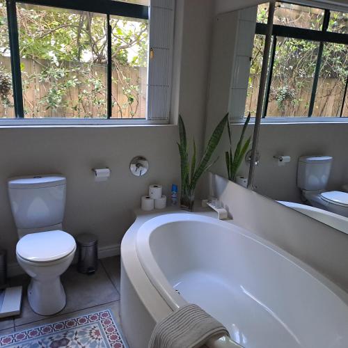 a bathroom with a tub and a toilet and a sink at Corgi Cottage in Stanford