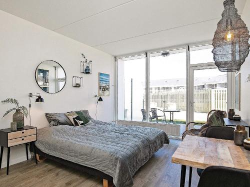 a bedroom with a bed and a living room with a table at 2 person holiday home in Ringkøbing in Ringkøbing