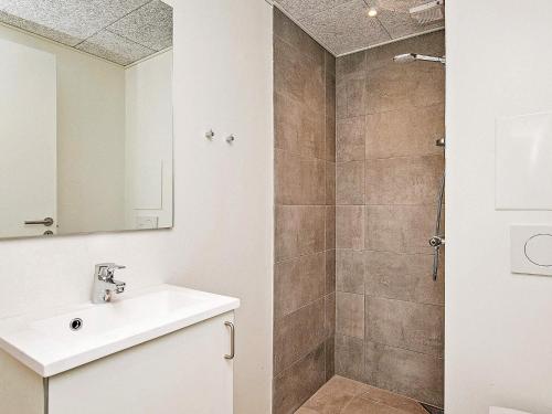 a bathroom with a white sink and a shower at 2 person holiday home in Ringkøbing in Ringkøbing