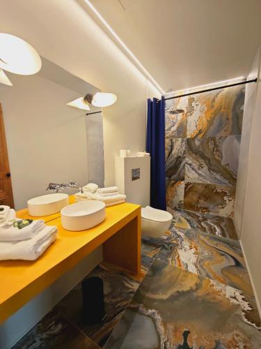 - une salle de bains avec 2 toilettes et un tableau mural dans l'établissement Hôtel Relais Monceau, à Paris
