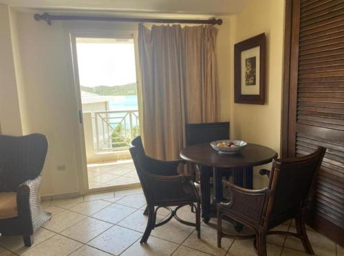 a dining room with a table and chairs and a window at Costa Bonita in Culebra