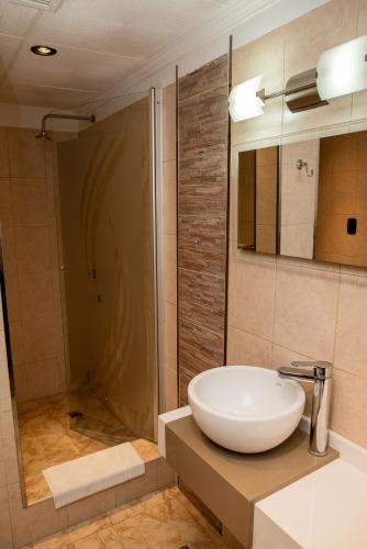 een badkamer met een witte wastafel en een douche bij Cristal Hotel in Eduardo Castex