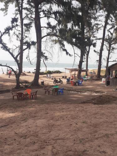 a park with picnic tables and trees on the beach at Guest House La Maison des Amis in Abene