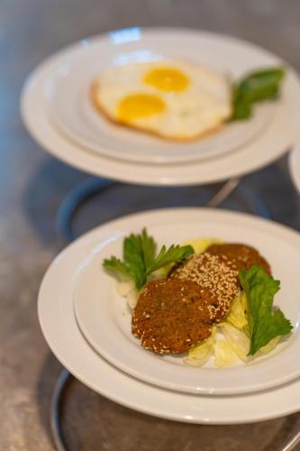 two plates of food with an egg on a table at Porto Marina Resort & Spa Al Alamein in El Alamein