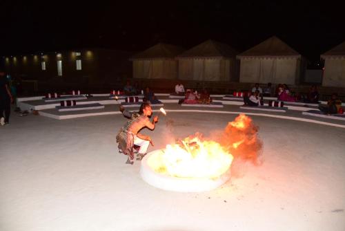 a man on a skateboard is around a fire at Malra Heritage Resort Jaisalmer in Sām