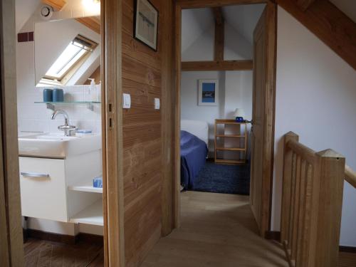 La salle de bains est pourvue d'un lavabo et d'une porte menant à une chambre. dans l'établissement Maison soignée 800m port et plage, Le Palais, 2 ch, jardin, Wi-Fi, TV, proche commodités - FR-1-418-218, au Palais