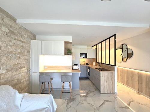 une cuisine avec une table et des chaises dans une pièce dans l'établissement Superbe appartement vue mer - Terrasse - Parking, à Villeneuve-Loubet