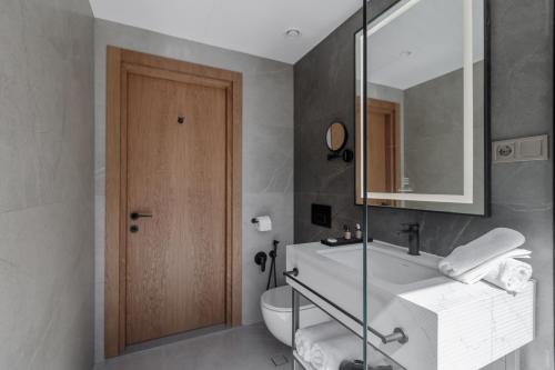 a bathroom with a sink and a toilet and a mirror at Piazza Epigraph in Batumi