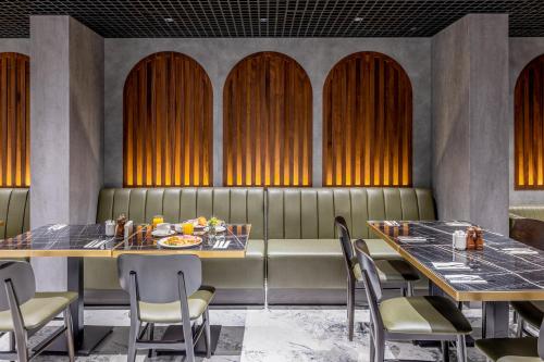 a dining room with two tables and chairs at Piazza Epigraph in Batumi