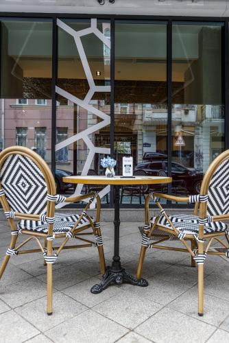 two chairs and a table in front of a store at Piazza Epigraph in Batumi