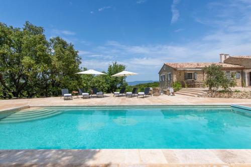 - une piscine avec des chaises et des parasols en face d'une maison dans l'établissement Elegant Provenal Villa in Bonnieux with Garden Private Pool - La Bcasse, à Bonnieux