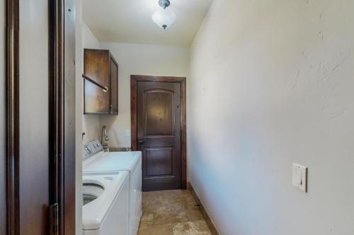 a laundry room with a washing machine and a door at Black Bear Lodge in Eagle