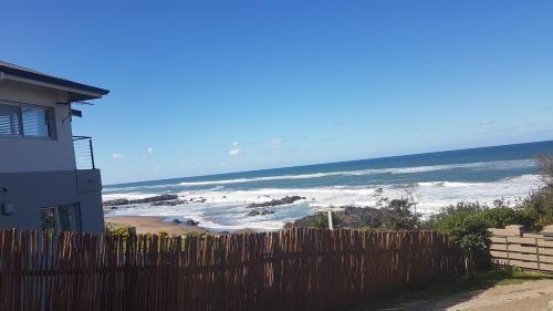 a view of the ocean from behind a wooden fence at Porta Salutis in Port St Johns