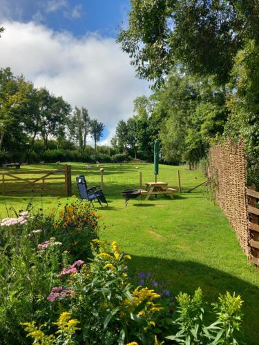 a park with a picnic table and chairs in the grass at Foxgloves in Brompton Regis