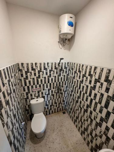 a bathroom with a toilet and a water tank at Eisei House in Jakarta