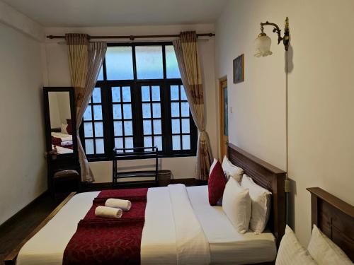 a bedroom with a bed with a large window at Chez Allen in Nuwara Eliya