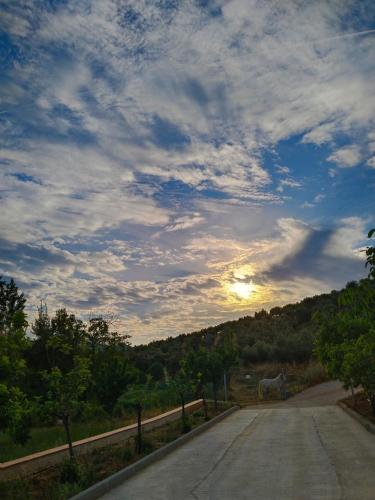 an empty road with the sunset in the sky at apartamentos turisticos la gitanilla in Los Navalucillos