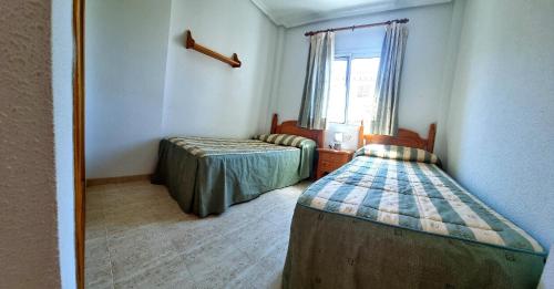 Ένα ή περισσότερα κρεβάτια σε δωμάτιο στο Chalet 3 dormitorios en VERAMAR 5 con jardín