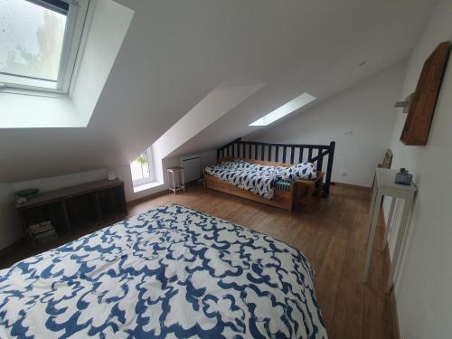 une chambre mansardée avec un lit et une fenêtre dans l'établissement Lulu's Lovely City Center House Le Mans, au Mans