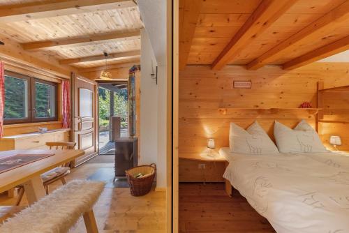 a bedroom in a log cabin with a bed and a desk at Chalet Laura al Passo della Mendola in Cavareno
