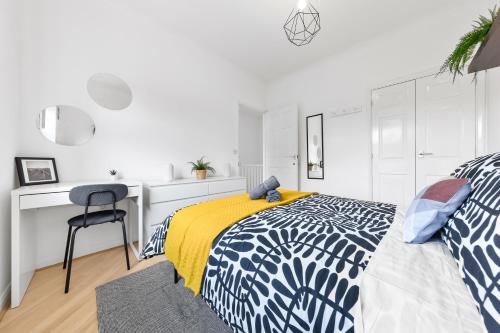a white bedroom with a bed and a desk at Cozylease 3 Bedroom Canary Wharf Family,Workcation, Fast WiFi, Workspace,1 stop to City in London