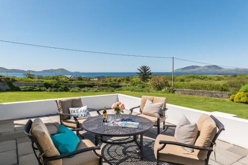 a patio with a table and chairs and the ocean at Cosy two bedroom cottage in Waterville with sea views in Waterville