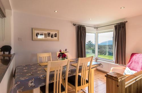a dining room with a table and chairs and a window at Cosy two bedroom cottage in Waterville with sea views in Waterville
