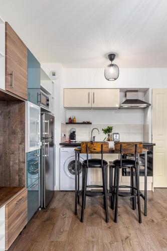 une cuisine avec une table avec des chaises et un réfrigérateur dans l'établissement Chez Julia et Kevin, à Serris