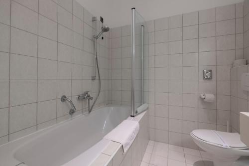a white bathroom with a tub and a toilet at Hotel Villa Annette in Rabac